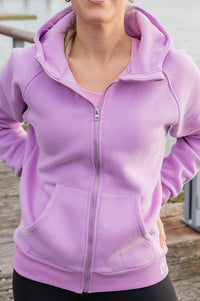 Person wearing a purple hoodie outdoors on a wooden deck
