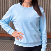 Women wearing a light blue sweatshirt.