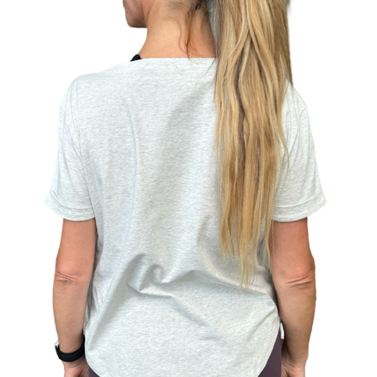 Woman wearing a grey t-shirt with scoop neck.