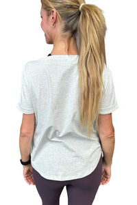 Woman wearing a grey t-shirt with scoop neck.