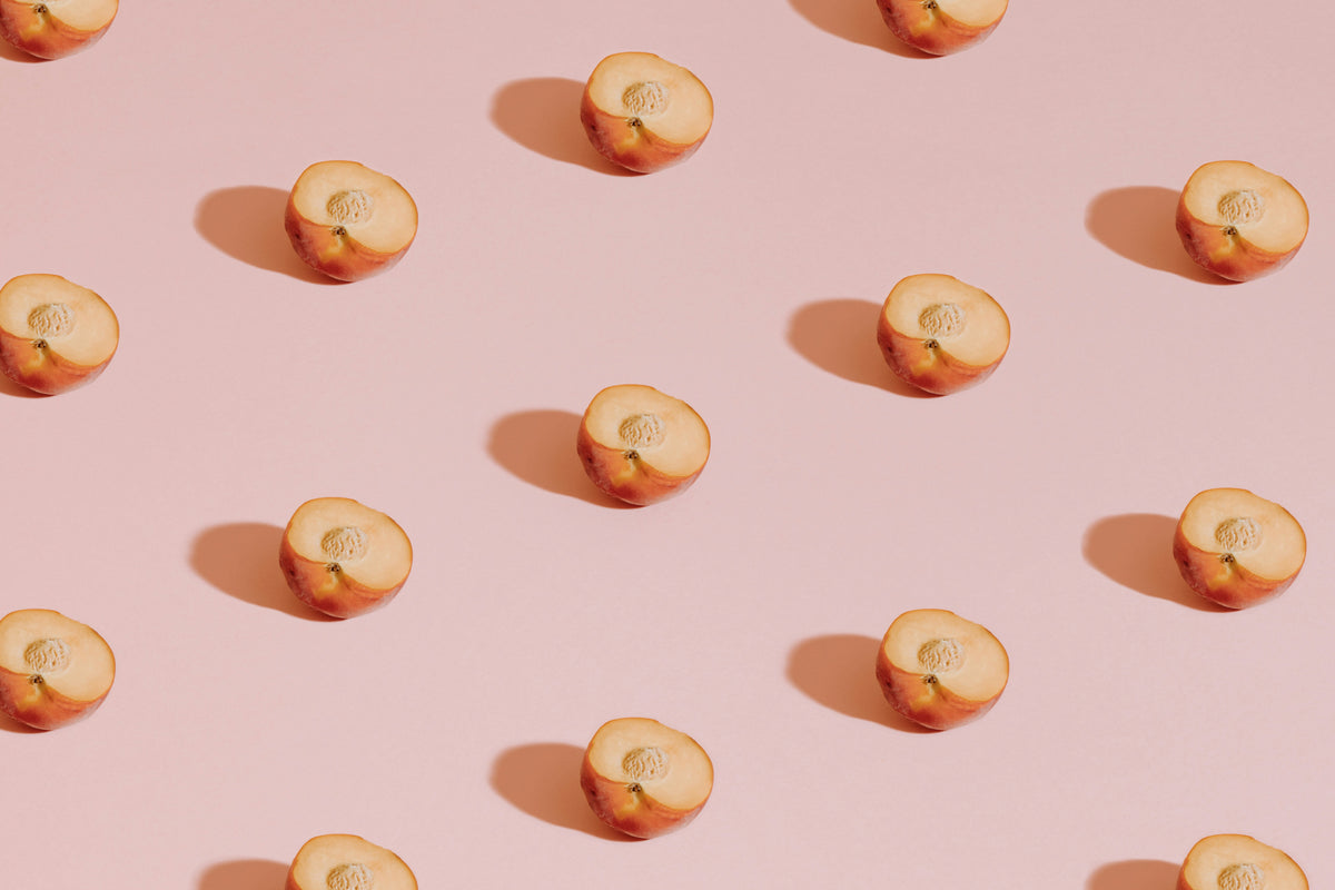 Pattern of sliced peaches on a pink background